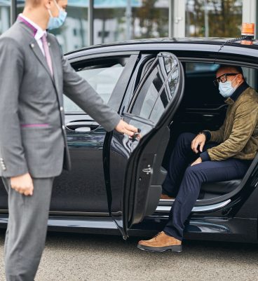 Man in eyeglasses getting out of the elite taxi Man in eyeglasses getting out of the elite taxi